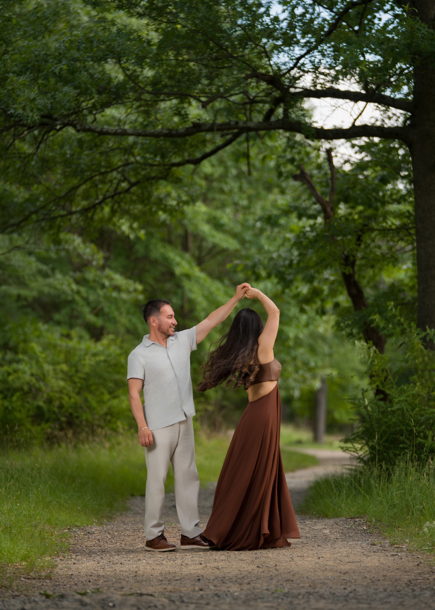 Karem and Eduardo sharing a joyful dance beneath the trees