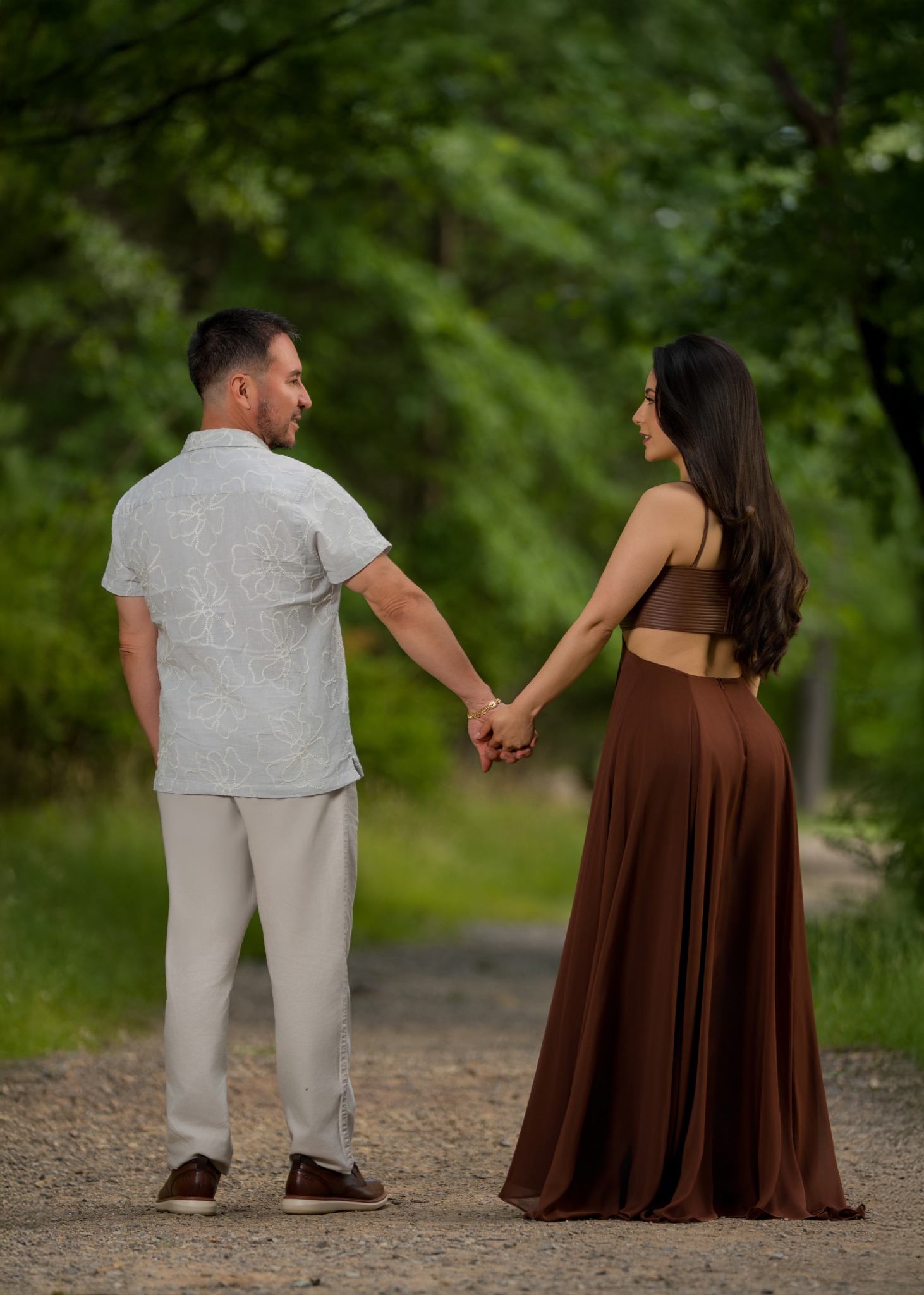 Karem and Eduardo standing side by side in a forest setting